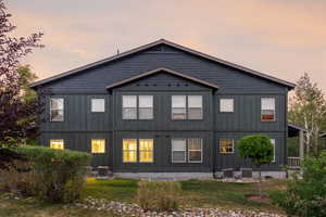 Back of house featuring board and batten siding and a yard