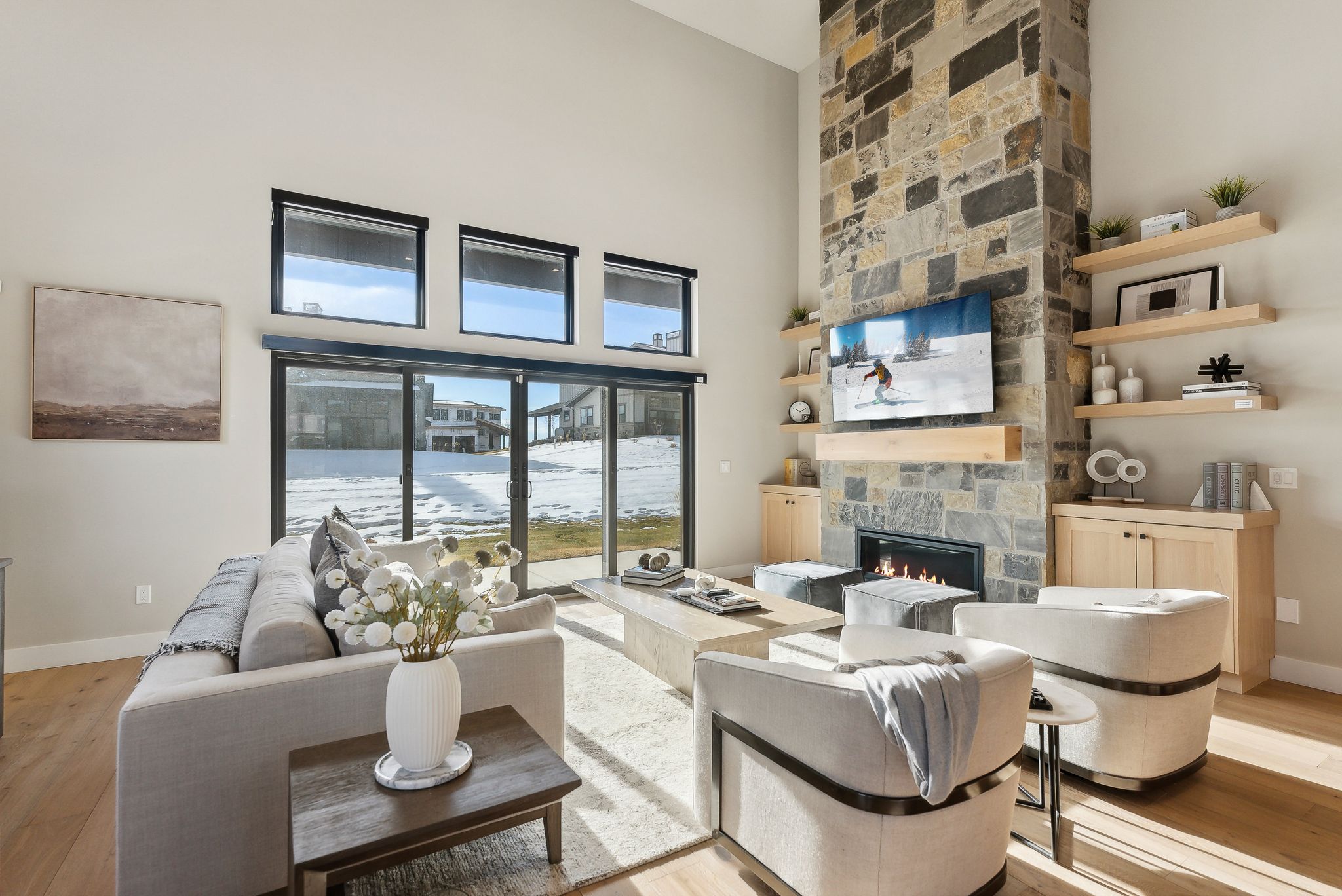 Living area with light wood-type flooring, a fireplace, and a high ceiling