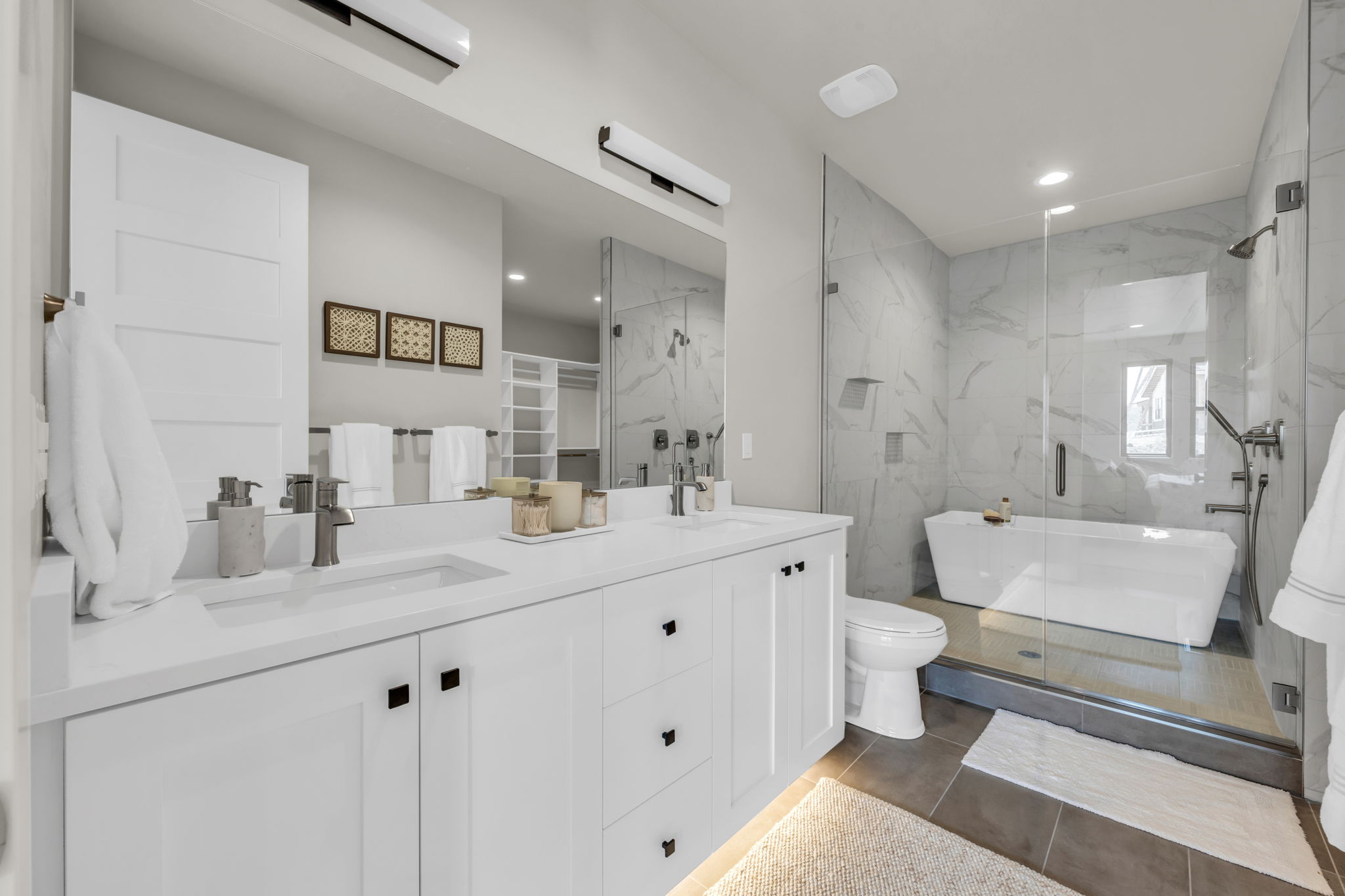 Full bathroom featuring a marble finish shower, double vanity, recessed lighting, and a freestanding bath