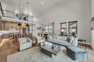 Living area featuring light wood-style floors, a high ceiling, and recessed lighting