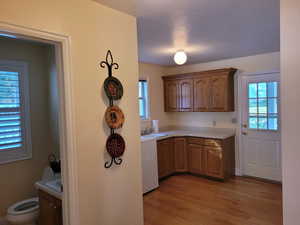 Kitchen with light countertops, light wood-type flooring, and brown cabinetry