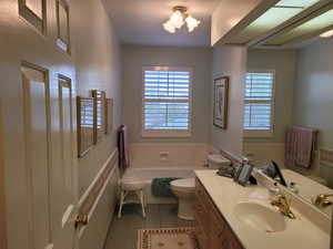 Full bath with tile patterned flooring, vanity, and a tub to relax in