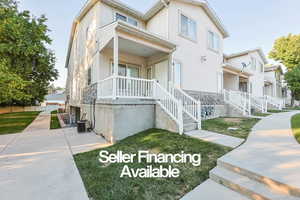 View of front facade with stone siding, stucco siding, and a porch