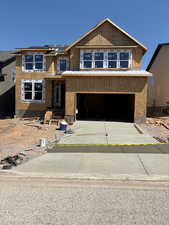 Unfinished property featuring an attached garage and driveway