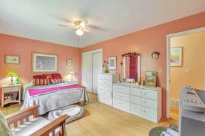 Bedroom featuring light wood-type flooring, a closet, and a ceiling fan
