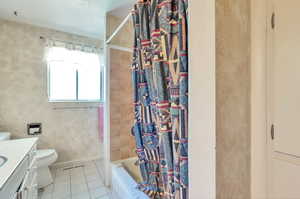 Full bathroom featuring vanity, tile patterned floors, and shower / bathtub combination with curtain