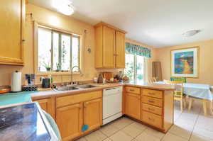 Kitchen featuring dishwasher, electric range, a peninsula, light countertops, and light tile patterned floors