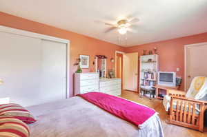 Bedroom with light wood-style flooring, a closet, and ceiling fan
