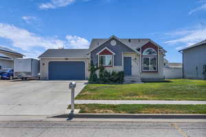 View of front facade featuring an attached garage, brick siding, driveway, a front lawn, and a shingled roof