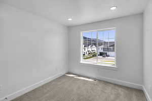 Carpeted bedroom with large windows and recessed lighting