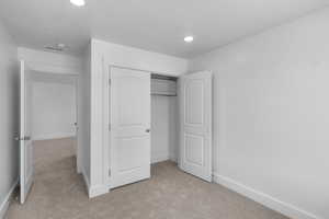 Bedroom featuring light carpet, a closet, and recessed lighting