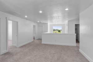 Carpeted living area featuring recessed lighting and large windows