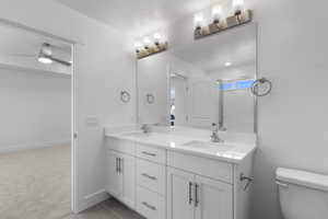 Full bathroom featuring double vanity and ceiling fan