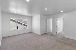 Carpeted living area featuring recessed lighting and large windows
