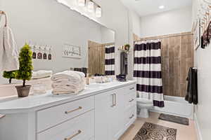 Full bathroom with vanity, shower / tub combo, and tile patterned flooring