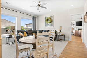 Dining area with a ceiling fan, light wood-type flooring, and recessed lighting