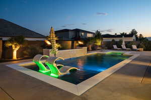 View of pool featuring a patio area, a fenced backyard, and a pool with connected hot tub