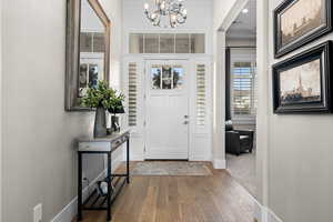 Foyer entrance with a chandelier and hardwood / wood-style flooring