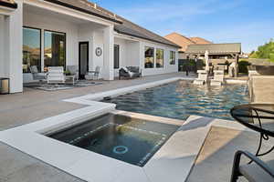 View of swimming pool featuring a patio area and a pool with connected hot tub