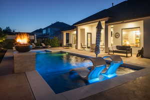 View of pool featuring a patio and an outdoor living space with a fire pit