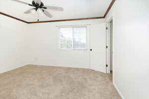 Unfurnished room with ornamental molding, carpet floors, and ceiling fan