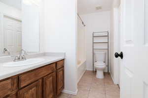 Bathroom with vanity, shower / tub combination, and light tile patterned floors