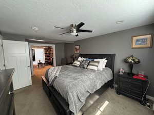 Carpeted bedroom with a textured ceiling, a ceiling fan, and recessed lighting