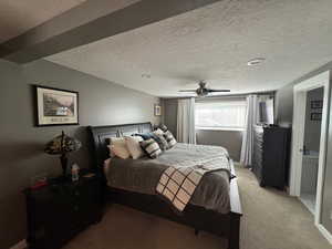 Bedroom featuring light colored carpet, a textured ceiling, and a ceiling fan
