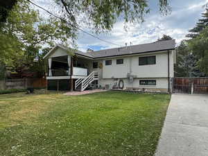Back of property featuring stairs, a chimney, a gate, and brick siding