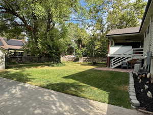 View of yard with a ceiling fan and stairs