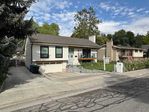 Split foyer home with driveway, a garage, and a chimney
