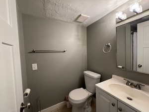 Full bath featuring a textured ceiling, vanity, and tile patterned flooring