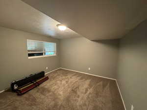 Carpeted spare room with baseboards and a textured ceiling