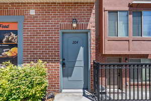 Doorway to property with brick siding and a gate