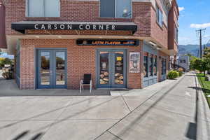 View of exterior entry featuring french doors, brick siding, and a mountain view