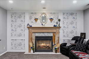 Carpeted living area with a tile fireplace and recessed lighting