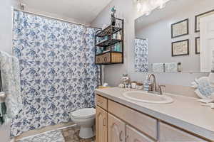 Bathroom featuring vanity, curtained shower, and tile patterned flooring