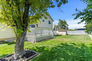 Rear view of property featuring a shed, a fenced backyard, and a deck
