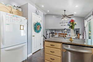 Kitchen featuring freestanding refrigerator, dishwasher, dark wood-style floors, ceiling fan, and light brown cabinetry