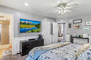Bedroom featuring wainscoting, carpet floors, and ceiling fan