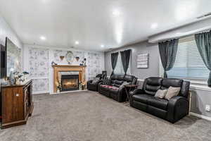 Living area featuring carpet, a fireplace, recessed lighting, and a textured ceiling