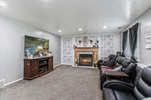 Living room with carpet flooring, a fireplace, and recessed lighting