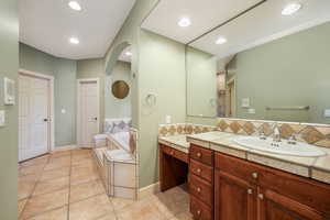 Main Bathroom featuring vanity, a bath, shower, tile patterned floors, tasteful backsplash, and recessed lighting
