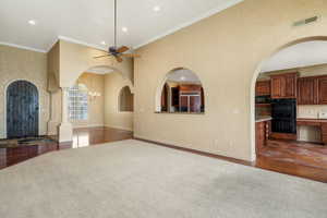 Unfurnished living room featuring ceiling fan, dark carpet, recessed lighting, dark wood-style flooring, and arched walkways
