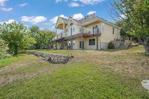 Rear view of property featuring stucco siding and a yard