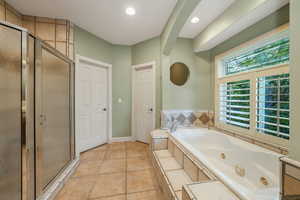 Bathroom featuring a whirlpool tub, a shower stall, recessed lighting, and tile patterned flooring