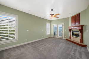 Main bedroom featuring a tile fireplace, plenty of natural light, french doors and carpet floors