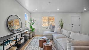 Living area featuring light wood finished floors and recessed lighting