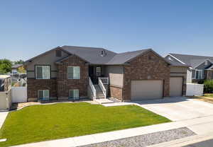 Ranch-style home featuring concrete driveway, brick siding, a garage, and stucco siding