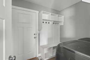 Mudroom with independent washer and dryer and dark wood finished floors